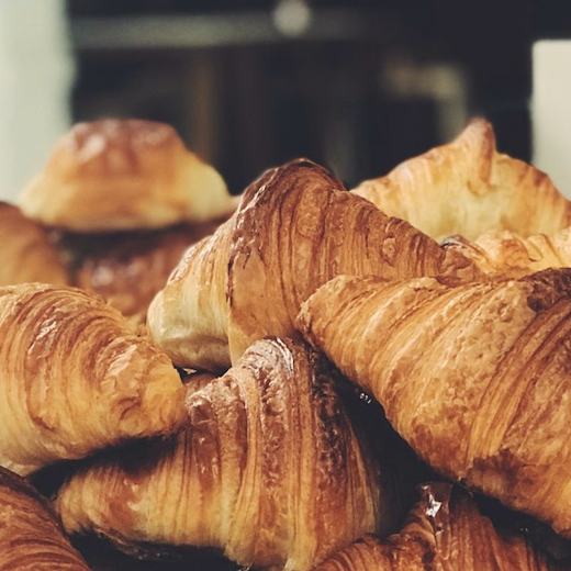 A tray of golden croissants on the bakery counter