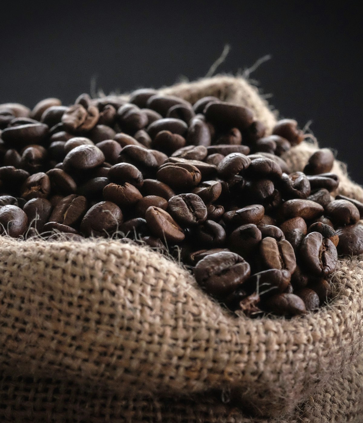 Freshly roasted beans spilling from a jute sack