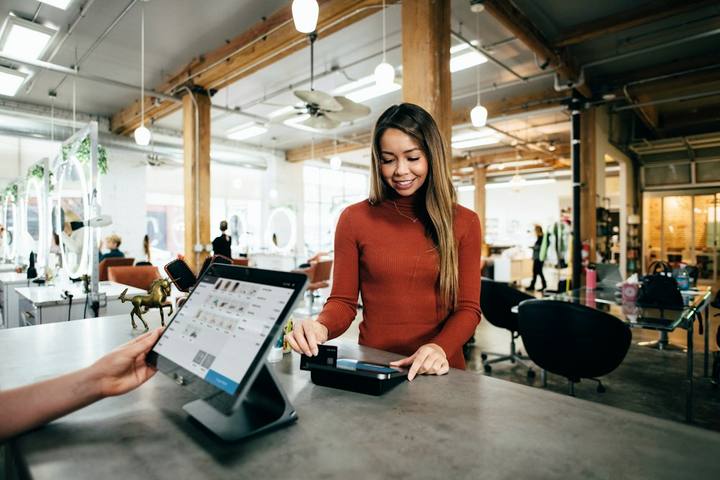A shop owner serving a customer at the counter