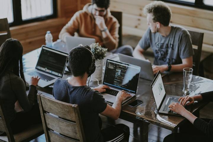 A startup team working on laptops around a shared table