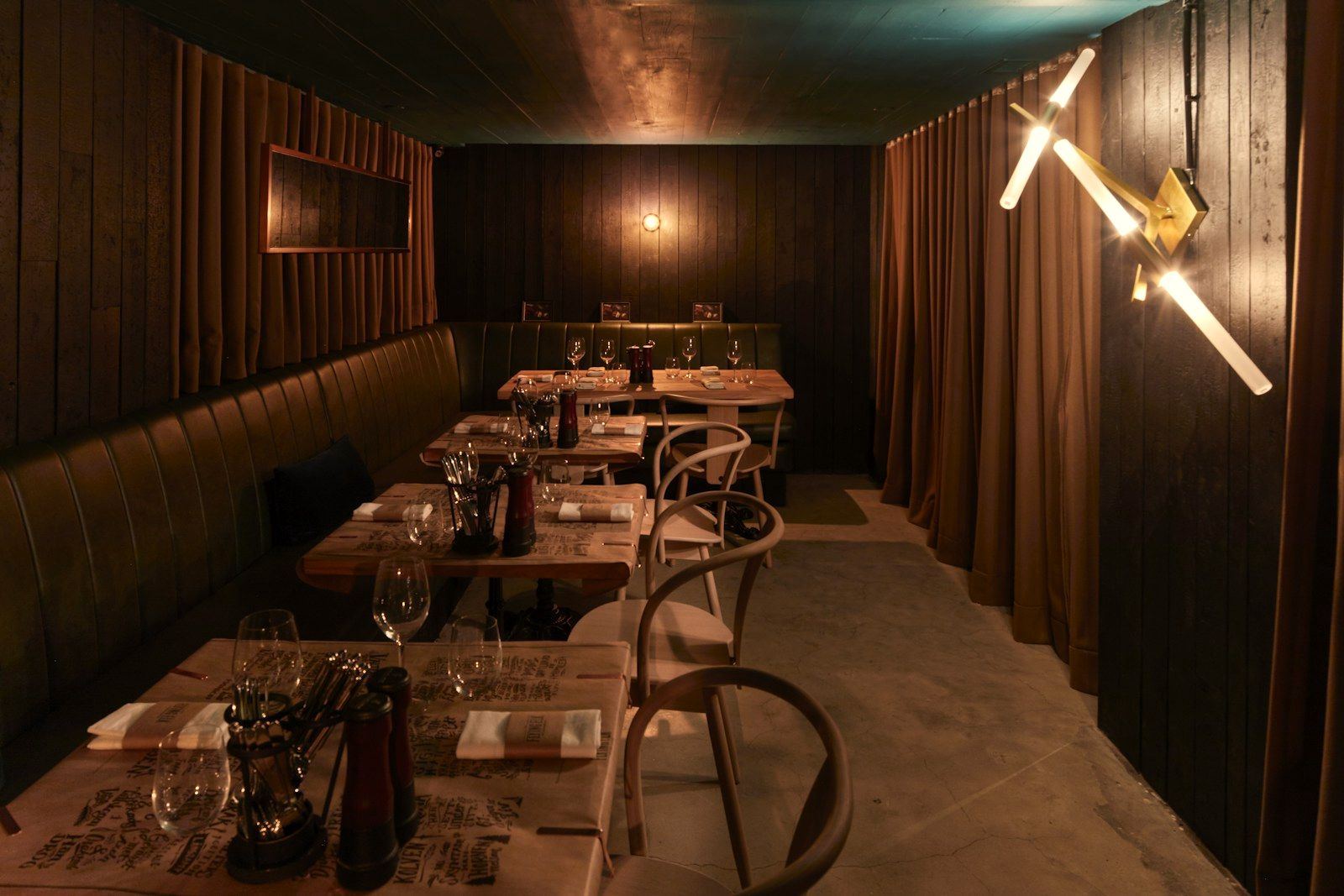 A low-lit private dining room with dark timber walls