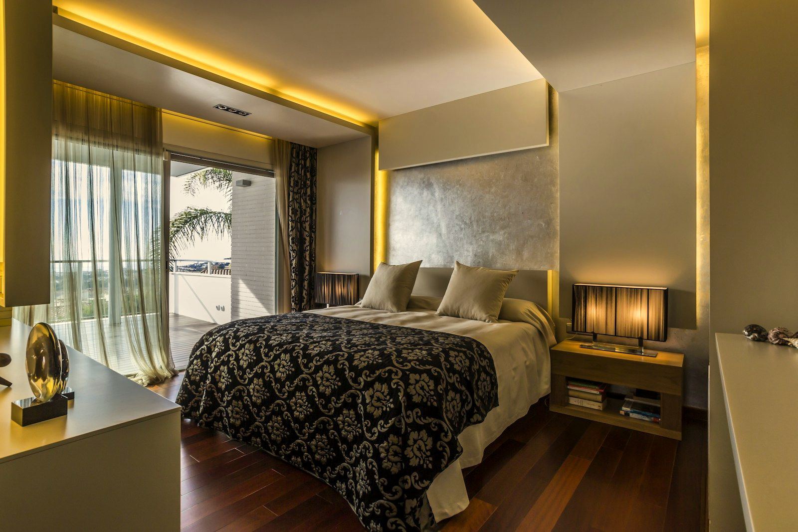 Penthouse bedroom with a silver-leaf headboard wall