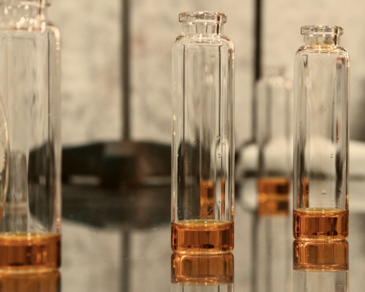 Small glass vials holding amber extrait