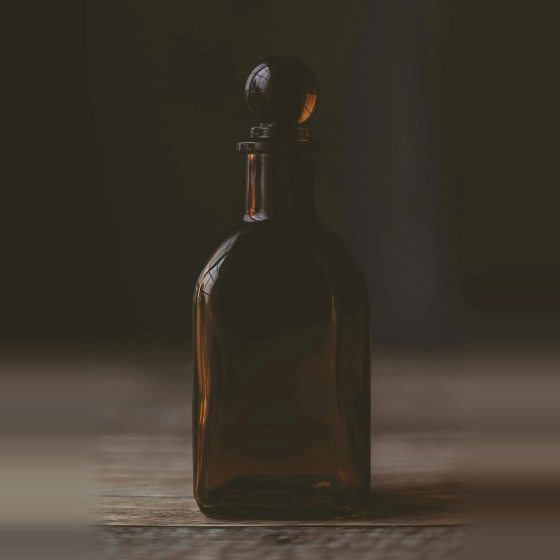 No. 11 Oud Nocturne, a dark amber decanter in low evening light