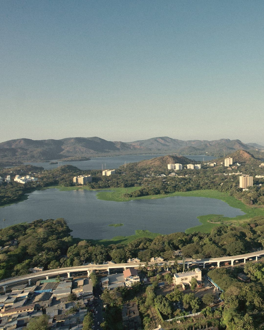 Powai Lake ringed by green hills and residential towers