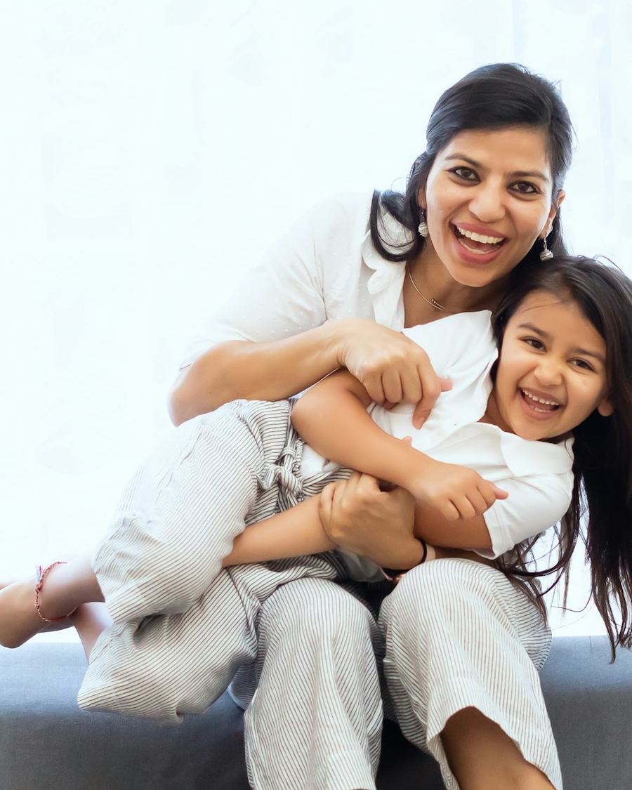 Mother and daughter laughing together on a sofa